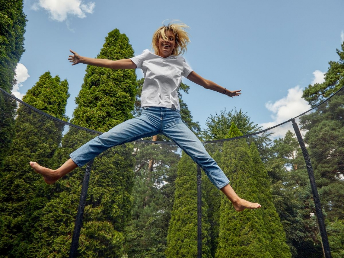 A woman happily jumping on a trampoline.jpg